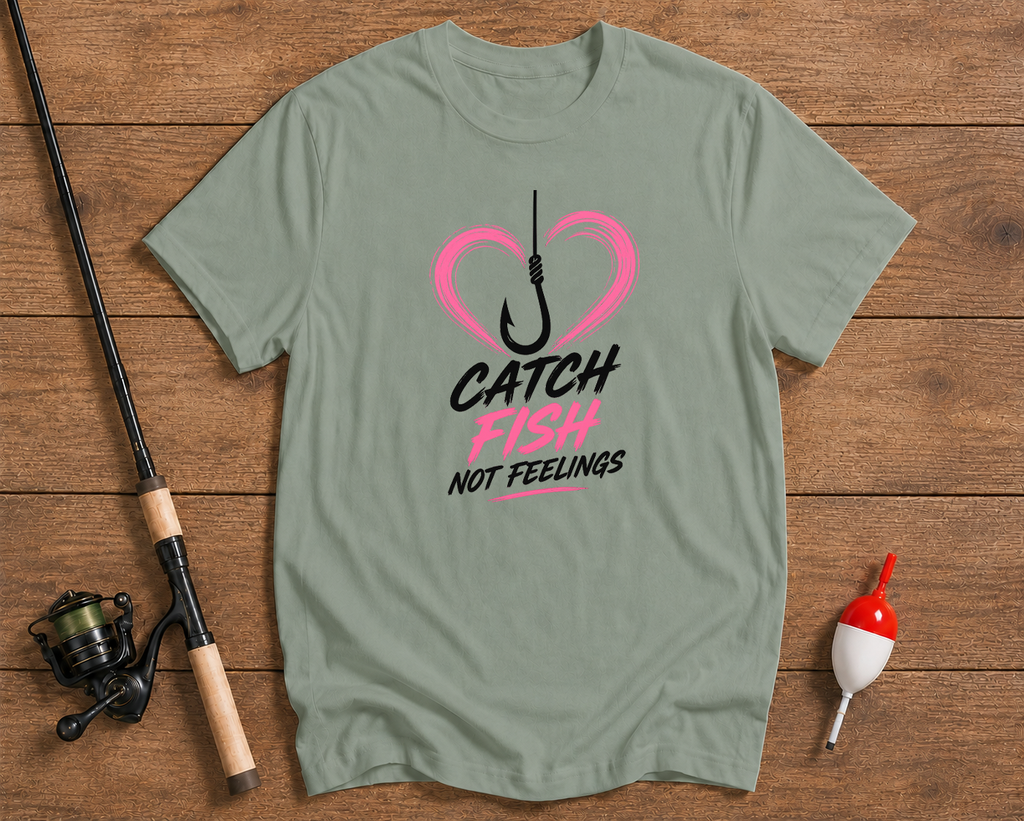 Green t-shirt with a heart and hook graphic and text on a wooden surface with fishing equipment.

