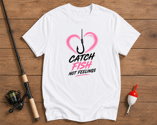 White t-shirt with a fishing-themed design on a wooden surface with fishing equipment.