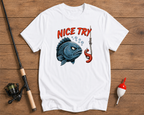 White t-shirt with a graphic design of a fish and lobster on a wooden surface with fishing equipment.

