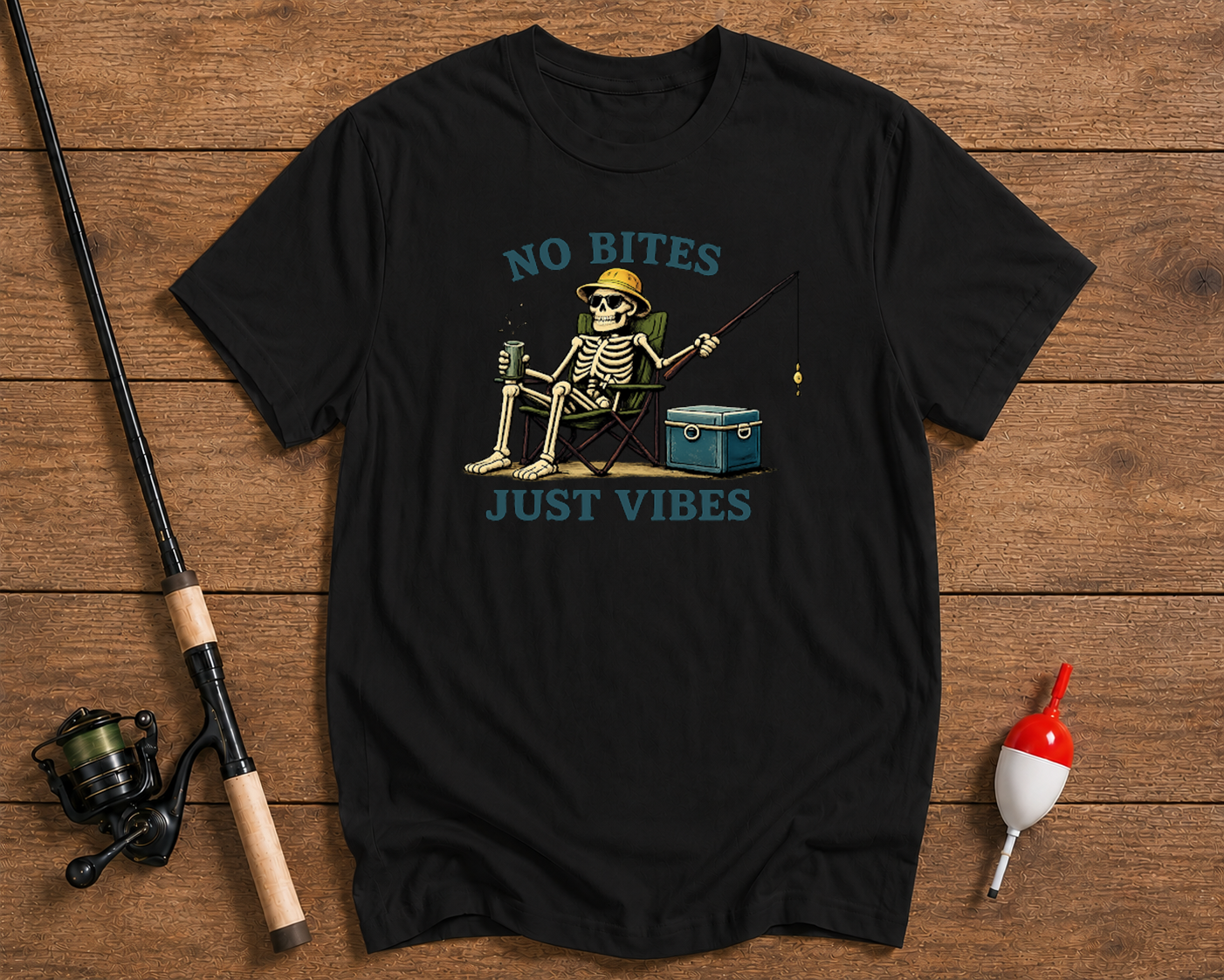 Black t-shirt with skeleton fishing graphic and 'No Bites Just Vibes' text on a wooden surface with fishing equipment.

