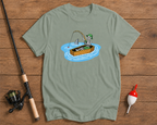 Green t-shirt with a skeleton fishing design on a wooden surface with fishing equipment.

