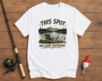 White t-shirt with fishing graphic and text on a wooden surface with fishing equipment.

